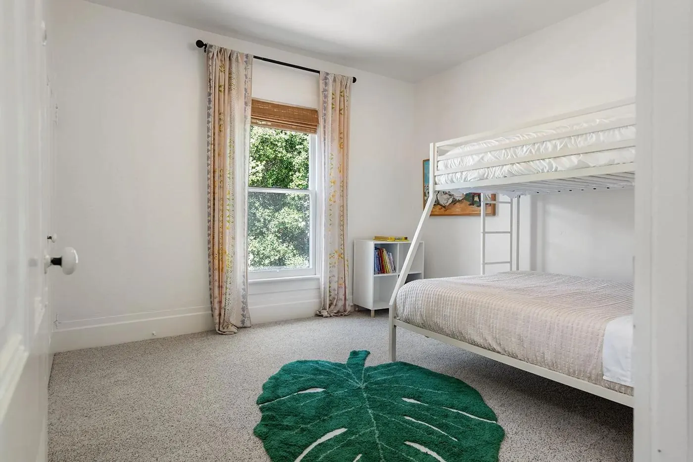 Bunk room with a twin-over-full bunk and leaf-shaped rug