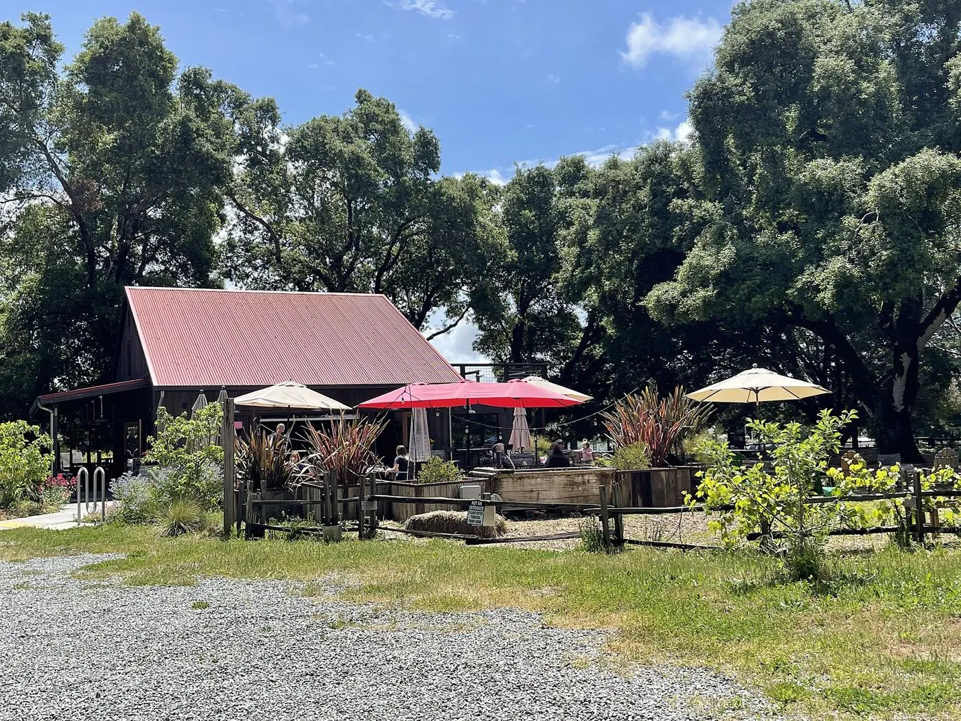 Horse & Plow's red-roofed tasting barn under oak trees